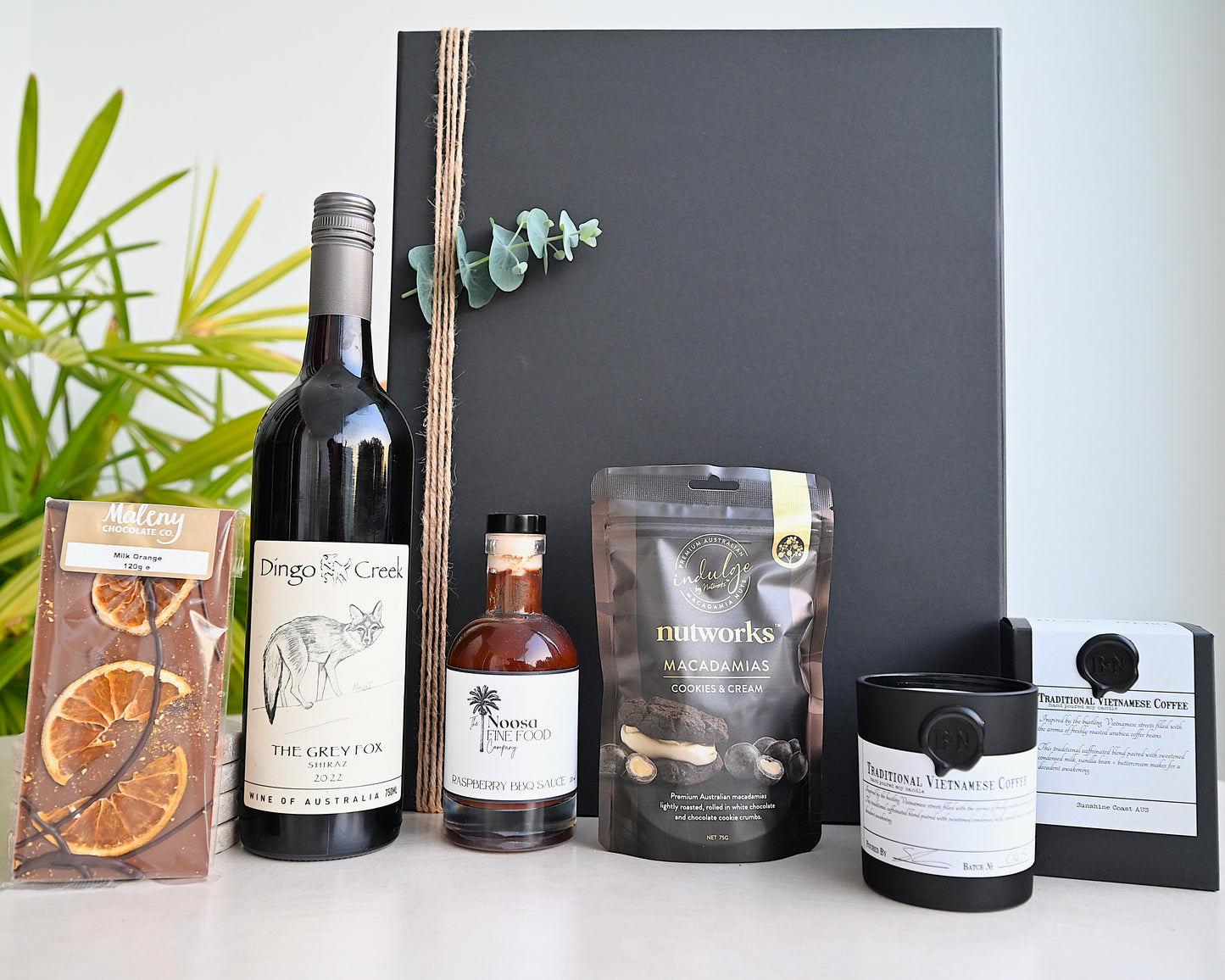 Collection of wine, coffee, and other products on a white surface with a blackboard background.