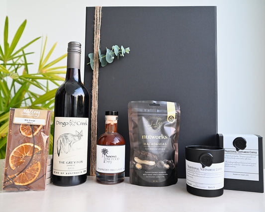 Collection of wine, coffee, and other products on a white surface with a blackboard background.