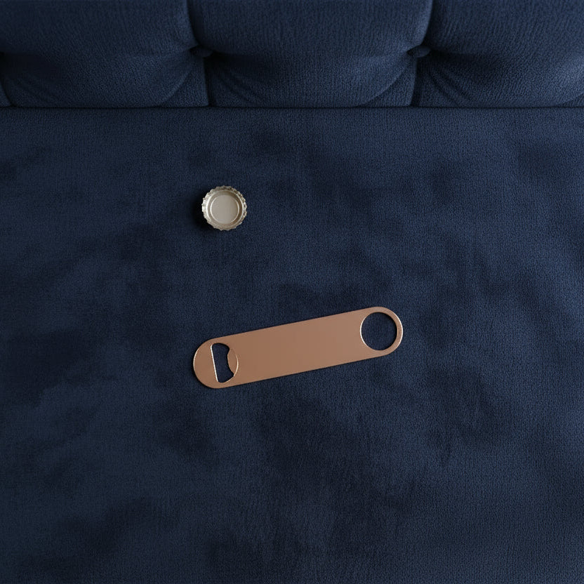 Navy blue fabric with a gold button and brown leather bottle opener on a dark background