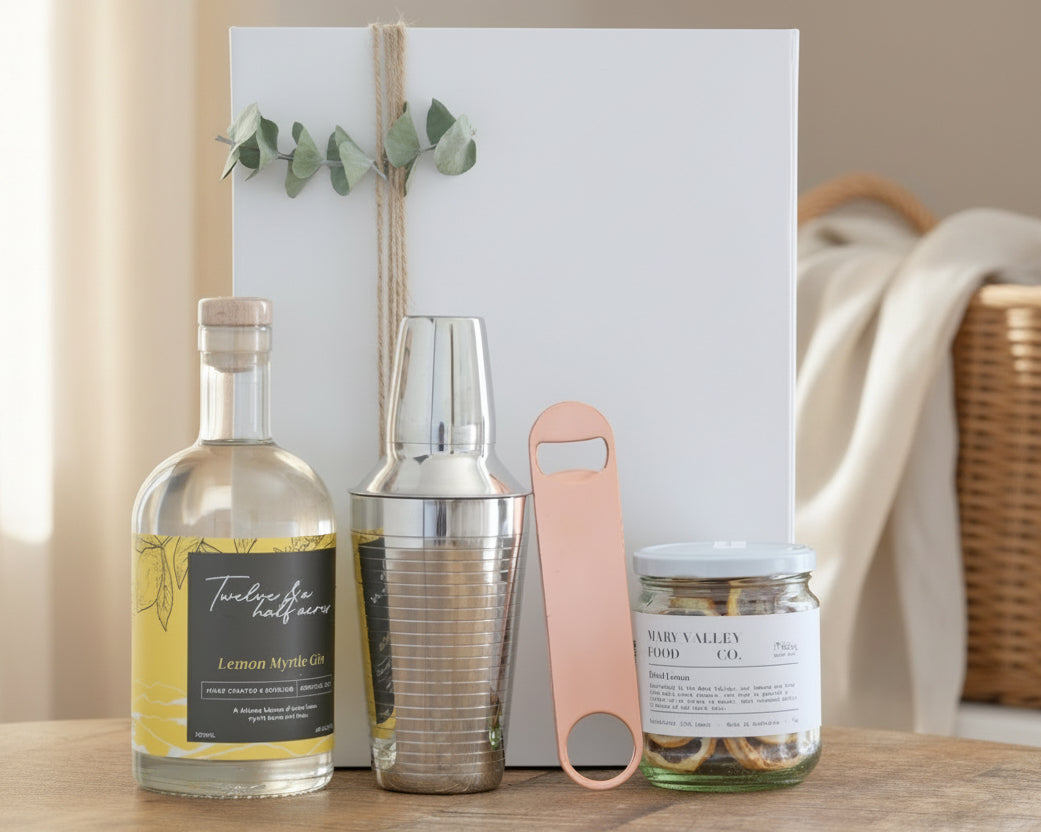 Beverage setup with bottles, shaker, and jar on a wooden surface.