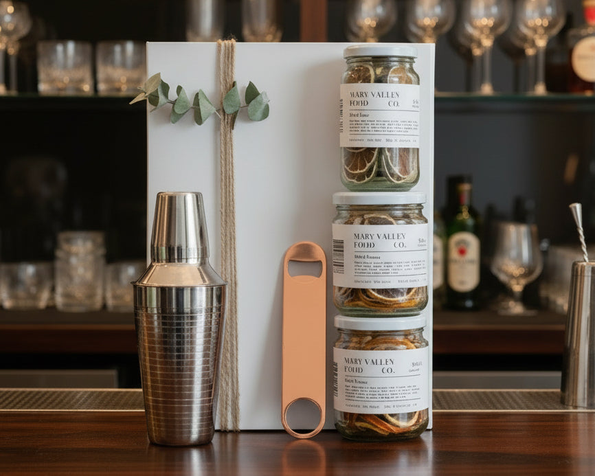 Cocktail hamper with cocktail shaker, bottle opener and dried lemon, lime and orange.