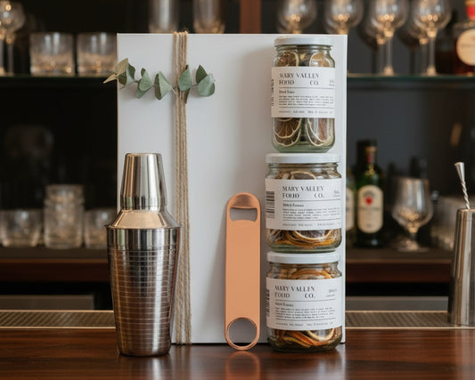 Cocktail hamper with cocktail shaker, bottle opener and dried lemon, lime and orange.