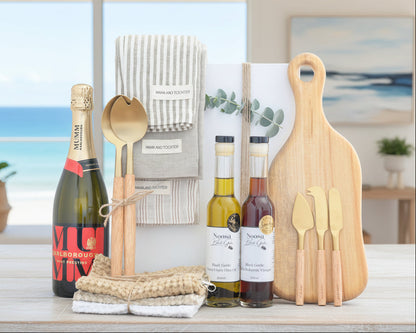 Wine bottles, cutting board, and utensils on a wooden surface with a neutral background