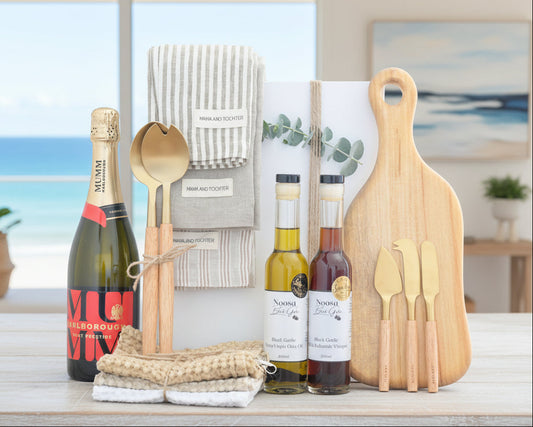 Wine bottles, cutting board, and utensils on a wooden surface with a neutral background